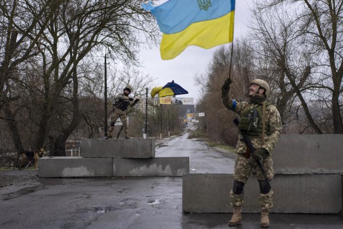 Ukrainas karavīri ar savas valsts karogiem pie viena no kontrolposteņiem, iebraucot Bučas pilsētā