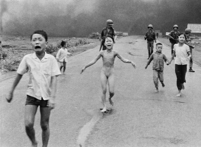 Bērni, kam seko Dienvidvjetnamas spēki, skrien pa 1. maršrutu netālu no Trangbangas pēc tam, kad Dienvidvjetnamas lidmašīna nejauši nometa liesmojošo napalmu uz saviem karavīriem un civiliedzīvotājiem, 1972. gada 8. jūnijā. Foto: AP/Scanpix