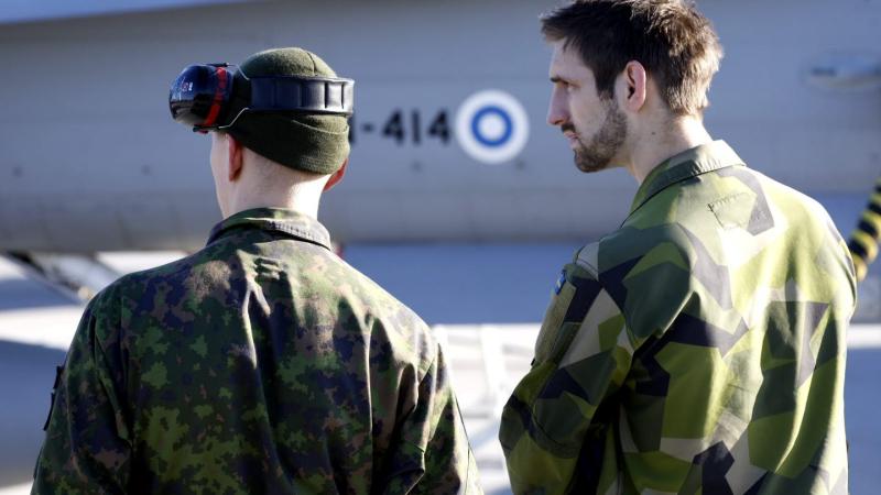 Zviedrijas un Somijas karavīri pie Somijas Gaisa spēku iznīcinātāja F-18 Gotlandes salā