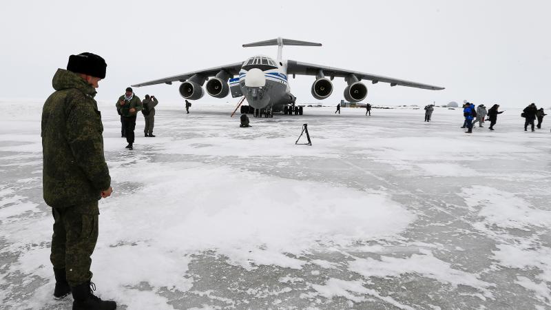 Krievijas karavīrs stāv uz Arktikā ierīkota skrejceļa pie agresorvalsts gaisa spēku lidmašīnas Il-76