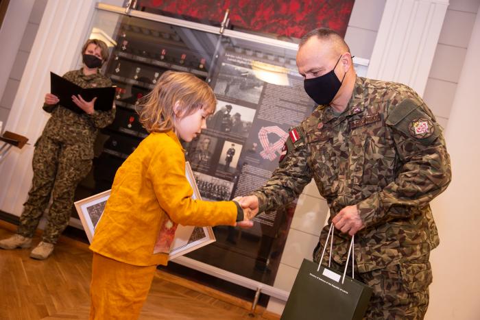 Zemessardzes komandieris brigādes ģenerālis Egils Leščinskis pasniedz veicināšanas balvu konkursa "Mans sveiciens Zemessardzei" jaunākajam dalībniekam Everestam Lūkinam/Gatis Dieziņš/Aizsardzības ministrija