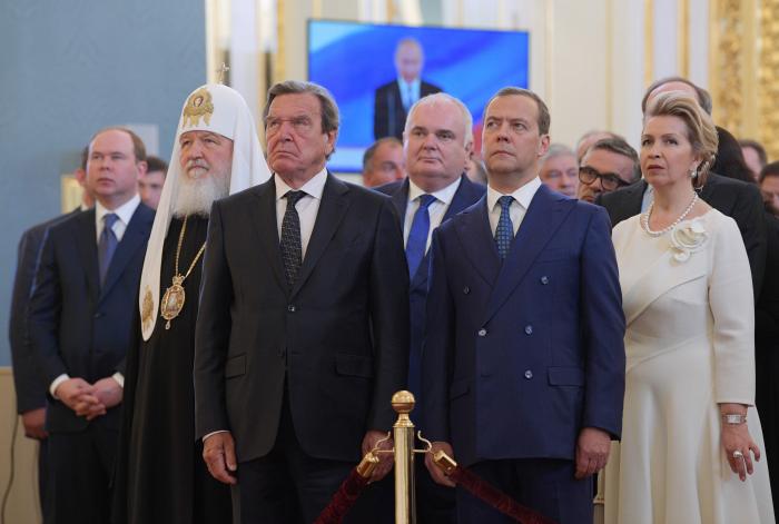 Bijušais Vācijas kanclers un "Nord Stream" akcionāru padomes priekšsēdētājs Gerhards Šrēders kopā ar "Nord Stream AG" valdes priekšsēdētāju, bijušo VDR slepenā dienesta "Stasi" virsnieku Matiasu Varnigu, Krievijas drošības padomes priekšsēdētāja vietnieku un bijušo Krievijas prezidentu un premjeru Dmitriju Medvedevu un Krievijas pareizticīgās baznīcas patriarhu Kirilu vēro V. Putina inaugurāciju 2018. gadā/AFP/Scanpix 