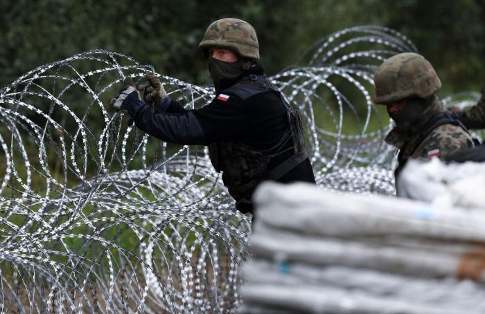Polijas bruņoto spēku karavīri būvē dzeloņstiepļu žogu uz robežas ar Baltkrieviju/AFP/Scanpix