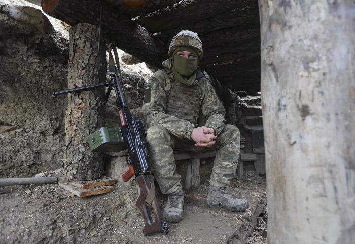 Ukrainas karavīrs ierakumos pie frontes līnija ar Krievijas separātistiem/Foto: AP/Scanpix