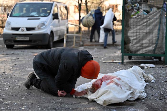 Vīrietis sēro par bojāgājušo, kurš mira, kad Kijivā 2022. gada 17. martā dzīvojamajai ēkai trāpīja atlūzas no notriektas raķetes, Krievijas spēkiem bombardējot Ukrainas galvaspilsētu.