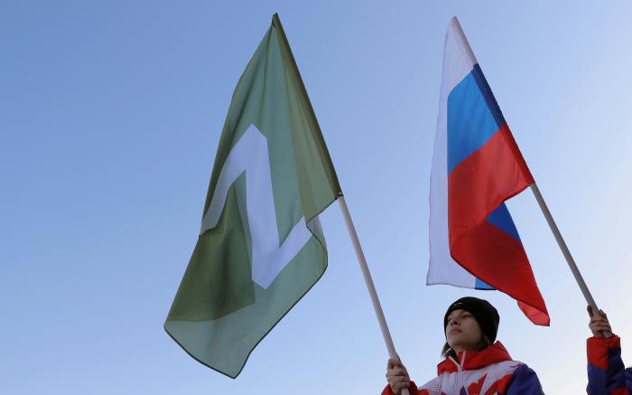 Rašistiski noskaņotie jaunieši tur rokās agresorvalsts Krievijas karogu un karogu ar Rietumu pasaulē aizliegto "Z"simboliku, o Krievija izmanto kā savu spēku atpazīšanās zīmi nelikumīgajā iebrukumā Ukrainā