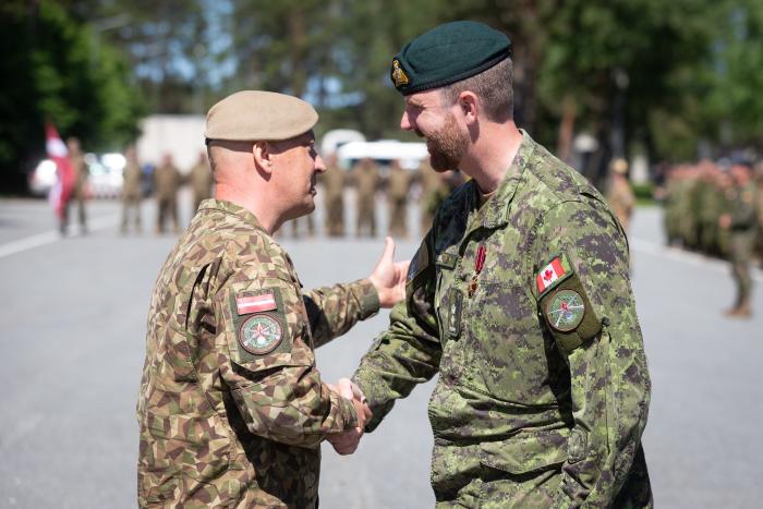 Sauszemes spēku Mehanizētās kājnieku brigādes komandieris pulkvedis Sandris Gaugers pasniedz apbalvojumu NATO daudznacionālās kaujas grupas Latvijā līdzšinējam komandierim Danam Dičelam (Dan Richel)