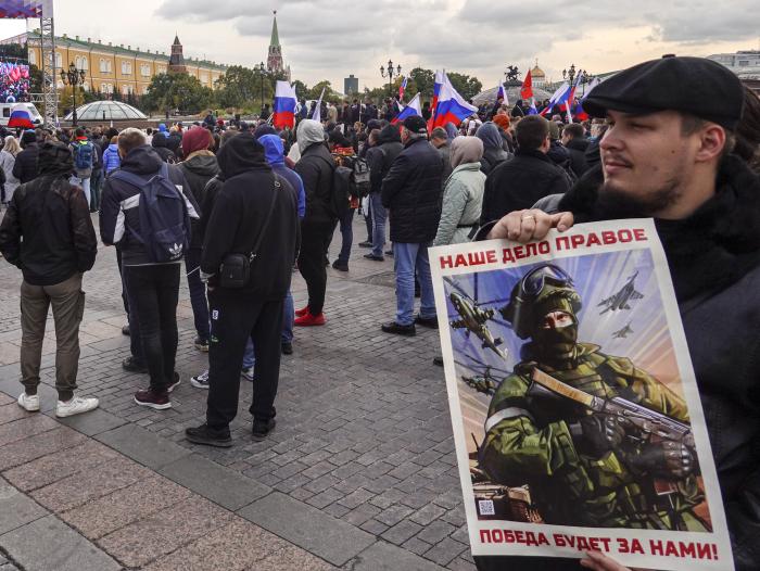 Diktatora un kara noziedznieka V. Putina režīmu atbalstošs cilvēks Maskavā Sarkanajā laukumā tur Krievijas noziedzīgo agresiju Ukrainā slavinošu plakātu