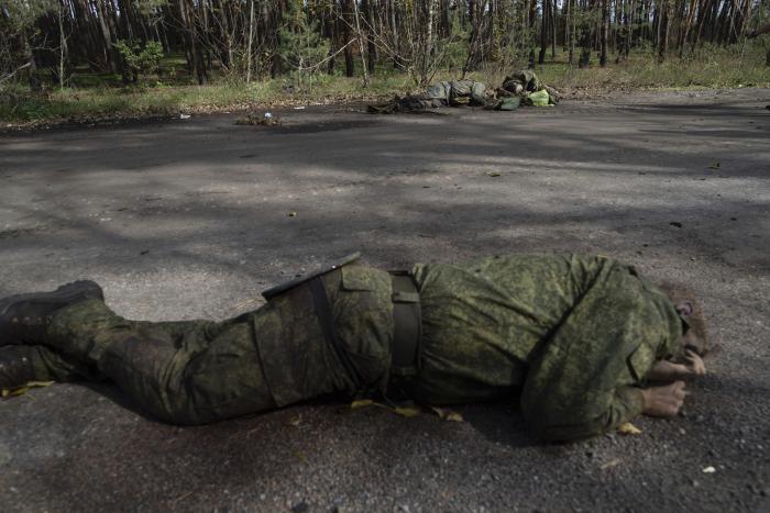Pirmdien, 2022. gada 3. oktobrī, nesen atgūtajā Laimanā, Ukrainā, uz zemes guļ Krievijas karavīru ķermeņi. Foto: AP/Scanpix