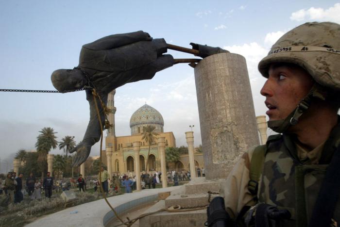 ASV jūras kājnieku korpusa uzbrucējs skatās, kā Bagdādes centrā krīt Irākas diktatora Sadama Huseina statuja. Foto: Reuters\Scanpix