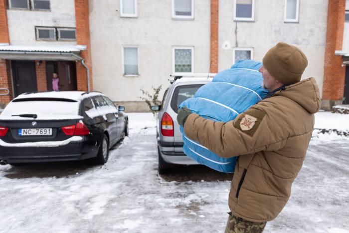 Zemessargs nes ukrainietei Lilijai Karaļovai humānās palīdzības paku. Foto: Gatis Dieziņš/Aizsardzības ministrija