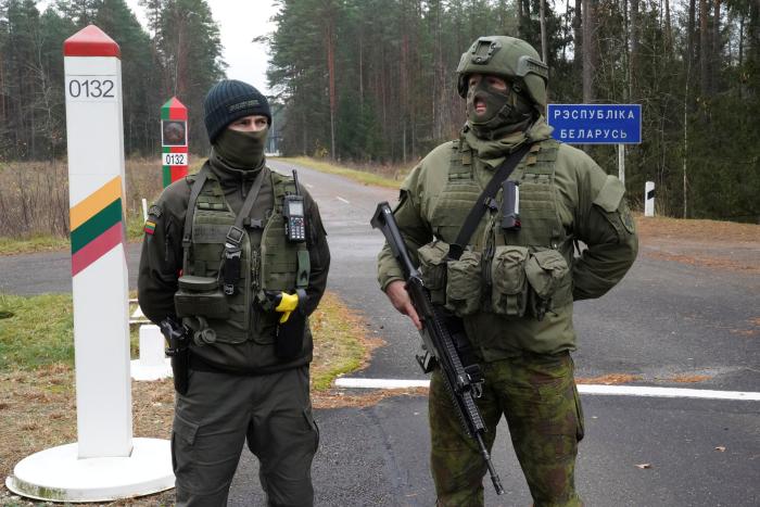 Lietuvas karavīrs ar robežsargu stāv pie Baltkrievijas robežas / Foto: Reuters/Scanpix