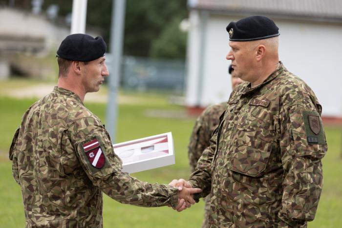 Zemessardzes komandieris pasniedz gada rakstu aizejošajam komandierim