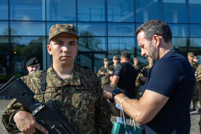 Tēvs pieliek uzšuvi savam dēlam