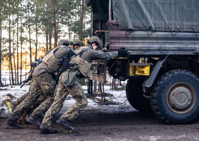 Sacīkšu dalībnieki stumj kravas mašīnu