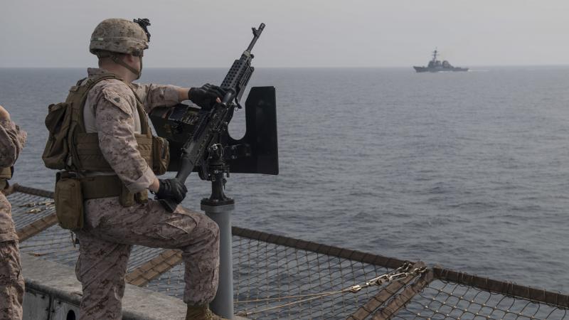 ASV karavīrs uz kuģa pie ložmetēja, šķērsojot Hormuza šaurumu