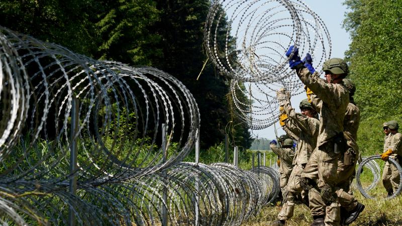 Lietuvas karavīri būvē dzeloņstiepļu žogu uz robežas ar Baltkrieviju