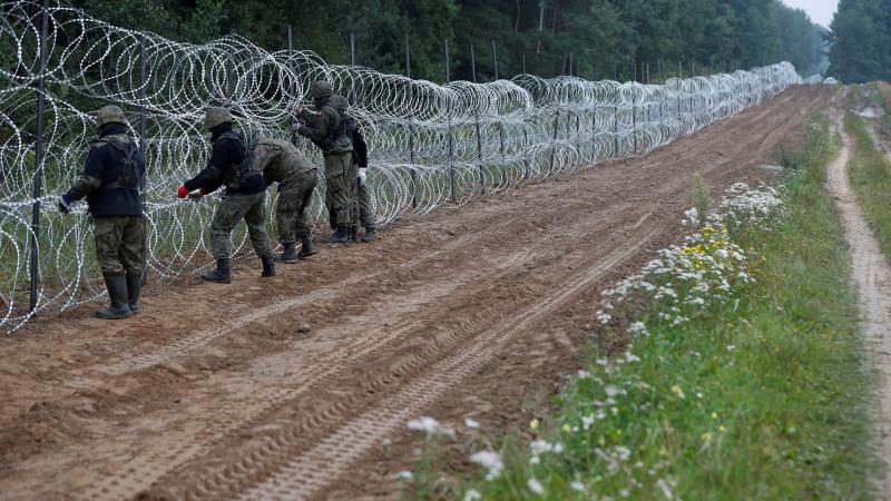 Polijas karavīri būvē žogu uz robežas ar Baltkrieviju