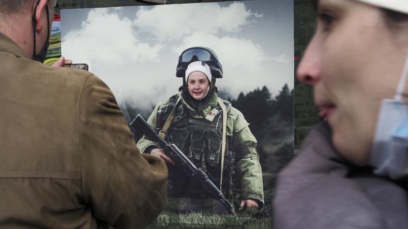 Meitene Krievijā fotogrāfējas Krievijas armija propagandas plakātā