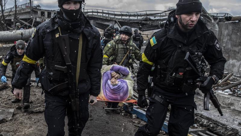 Ukrainas teritoriālās aizsardzības karavīri cenšas evakuēt gados vecu sievieti no Krievijas okupantu sagrautās Irpiņas