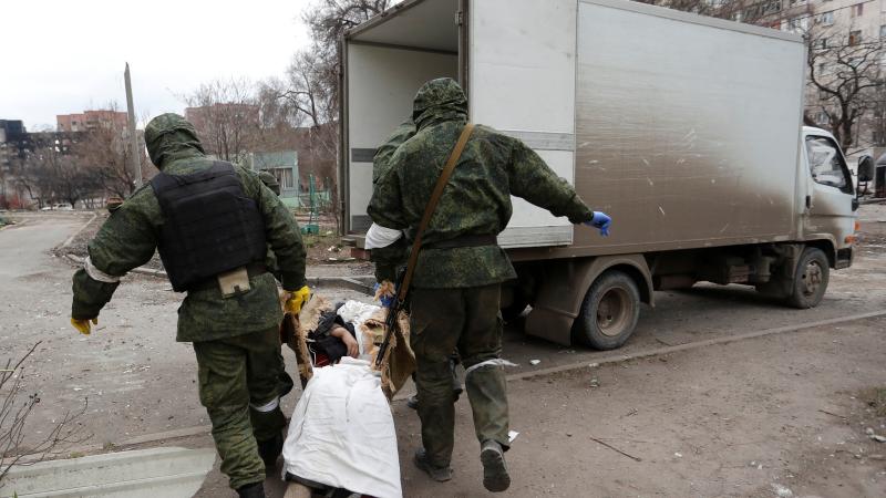 Prokrieviskā karaspēka dienesta locekļi savāc bojāgājušo līķus Mariupolē