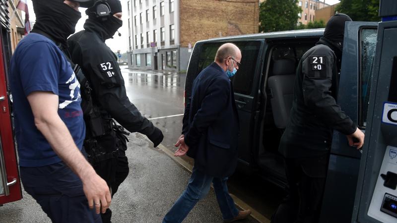 Valsts drošības dienesta darbinieki eskortē par spiegošanu apsūdzēto Saeimas deputātu Jāni Ādamsonu