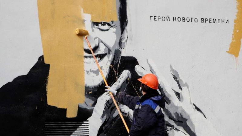 Strādnieks Sanktpēterburgā pārkrāso grafiti, kurā attēlots ieslodzītais Krievijas opozīcijas politiķis A.Navaļnijs. Uz grafiti rakstīts: "Jaunā laikmeta varonis". Foto: REUTERS/Antons Vaganovs/CEPA