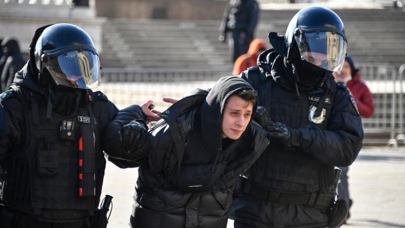 Krievijas policijas speciālo uzdevumu vienības kaujinieki brutāli aiztur vienu no mierīgajiem pretkara demonstrāciju dalībniekiem Maskavā