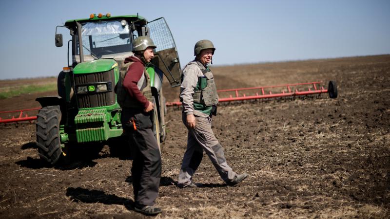 Ukrainas zemnieki, tērpušies bruņu vestēs un ķiverēs gatavojas pavasara labības sējai