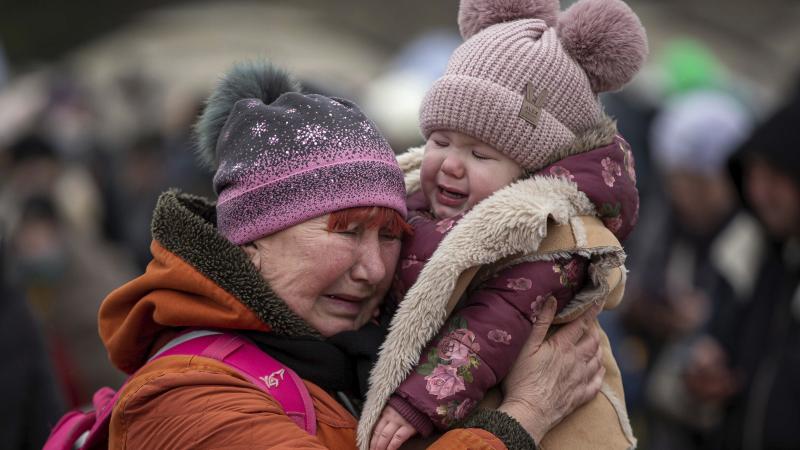 Raudoša Ukrainas iedzīvotāja ar bērnu, kuri bēg no krievijas izraisītā kara Ukrainā