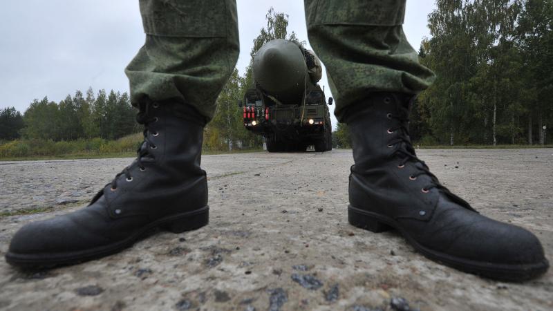 Kerievu karavīra zābaki mobilās starpkontinentālās ballistiskās raķetes palaišanas iekārtas fonā