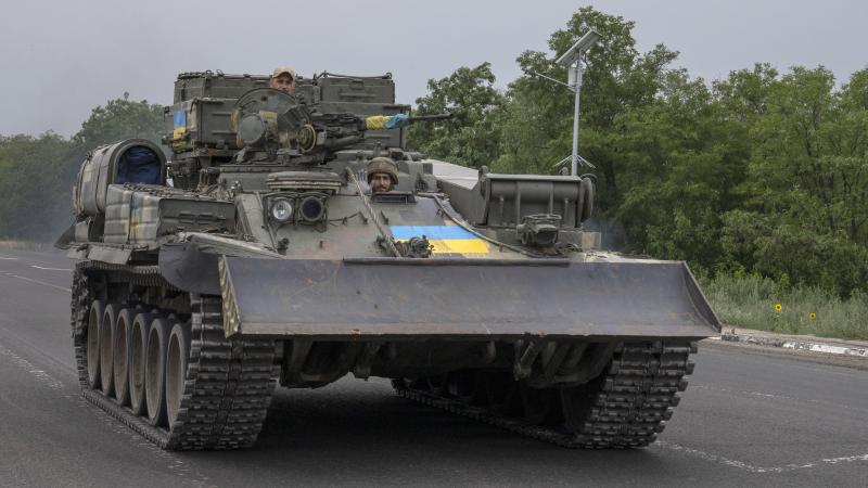 Ukrainas bruņoto spēku karavīri un tanks