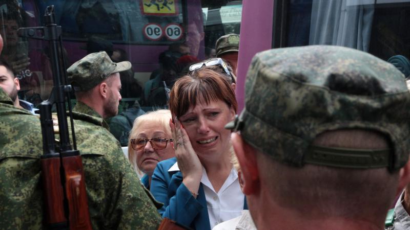 Sieviete raud Ukrainai piederošajā Krievijas okupētajā krimā pavadot agresorvalsts bruņotajos spēkos mobilizētos karavīrus