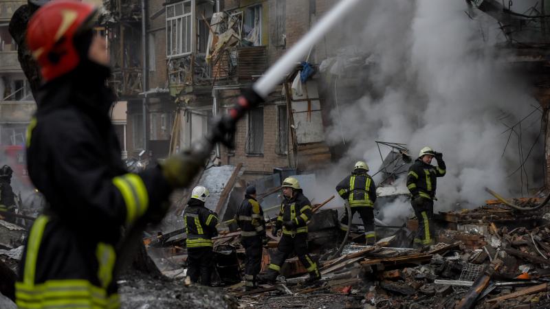 Ukrainas glābšanas dienestu darbinieki dzēš ugunsgrēkus un cenšas izglābt dzīvi palikušos pēc masīvā Krievijas raķešu uzbrukuma 23.novembrī