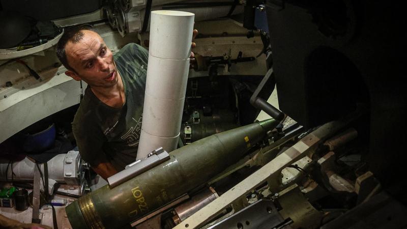 Ukraiņu artilērists lādē iekšā 155 milimetru šāviņu un pulvera lādiņu Polijas piegādātās pašgājēj haubices "Krab" stobrā 