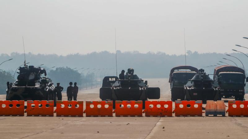 Mjanmas militārā hunta stāv sardzē kontrolpunktā ar bruņumašīnām, bloķējot ceļu uz parlamenta ēku 21.02.2021.