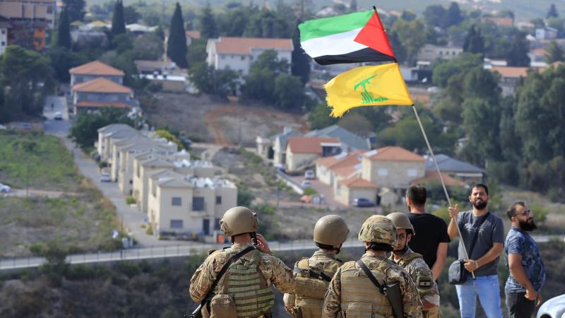 Vīrietis tur Palestīnas un "Hezbollah" karogu. 