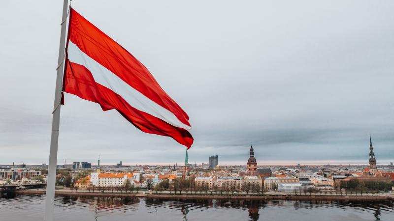 Latvijas karogs AB dambī un skats uz Vecrīgu