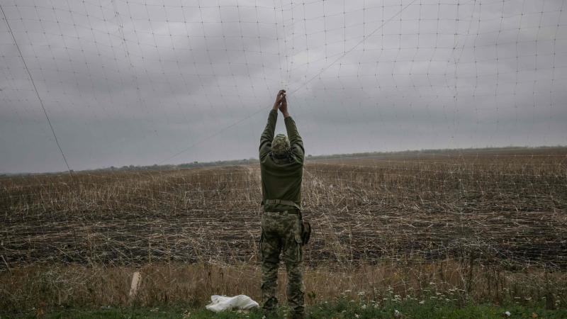 Ukrainas karavīrs frontē sien pretdronu tīklu