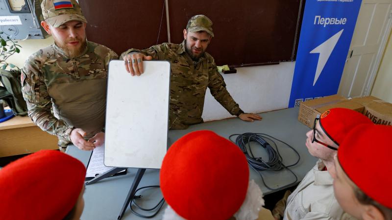 Okupanti demonstrē "Starlink" termināli skolā