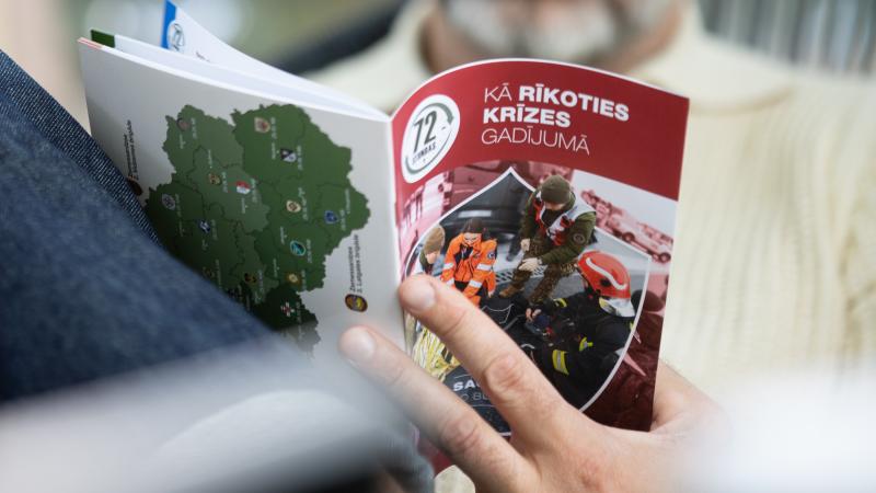 Cilvēks lasa bukletu