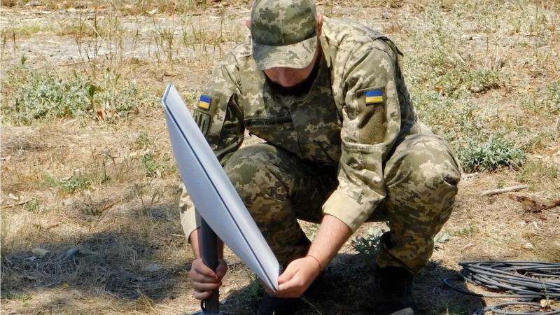 Ukraiņu karavīrs uzstāda "Starlink" satelīta interneta termināli